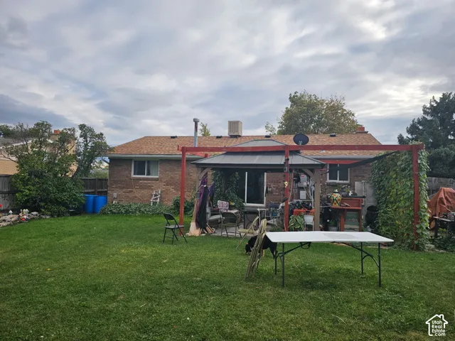 Brick exterior, backyard space, and permanent wooden pergola structure