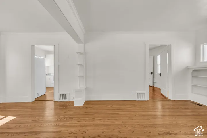 Wood-finish flooring, built-in shelving units, and arched door frames