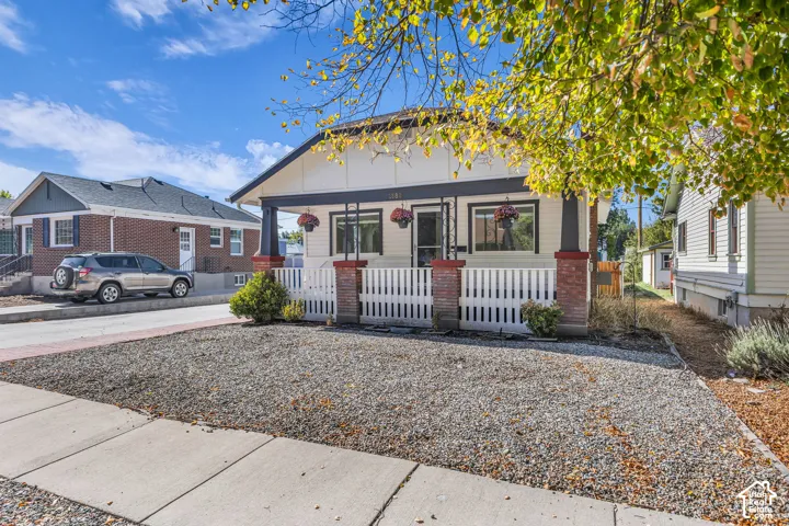 Exterior featuring a covered front porch with brick column bases, square support posts, and a white picket railing