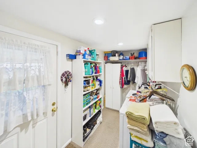 Laundry room featuring built-in cabinetry, wire shelving, recessed lighting, and a solid-panel entry door