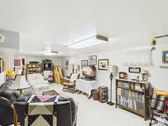 Neutral-toned interior space featuring light wall paint, wall-to-wall carpeting, and dual rectangular overhead light fixtures