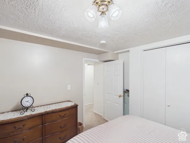 Neutral-toned interior space featuring a multi-bulb flush-mount ceiling fixture and double-door closet with white finish