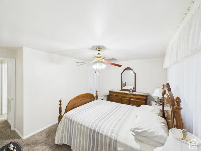 Neutral-toned interior featuring wall-to-wall carpeting and a central ceiling fan with multi-light fixture