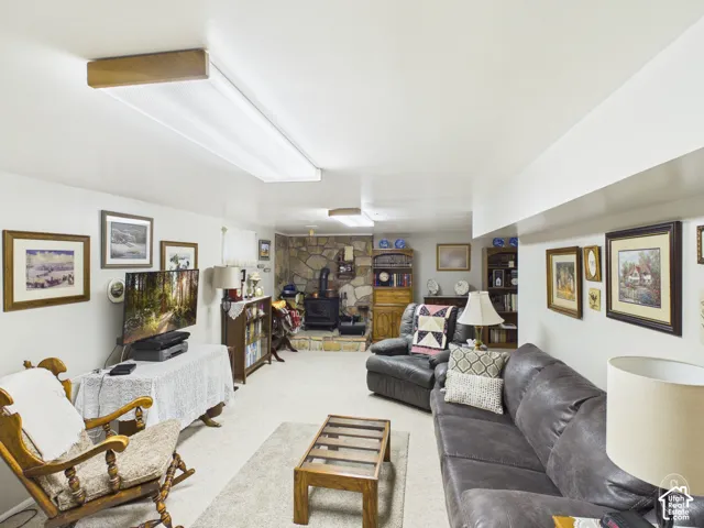 Living area featuring a floor-to-ceiling stone hearth with a wood-burning stove and recessed ceiling lighting