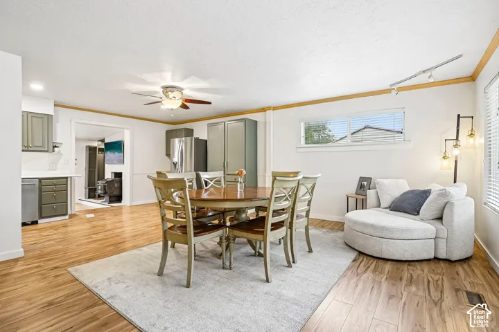 Open-concept living space featuring wood-finish flooring, recessed track lighting, ceiling fan, and built-in cabinetry