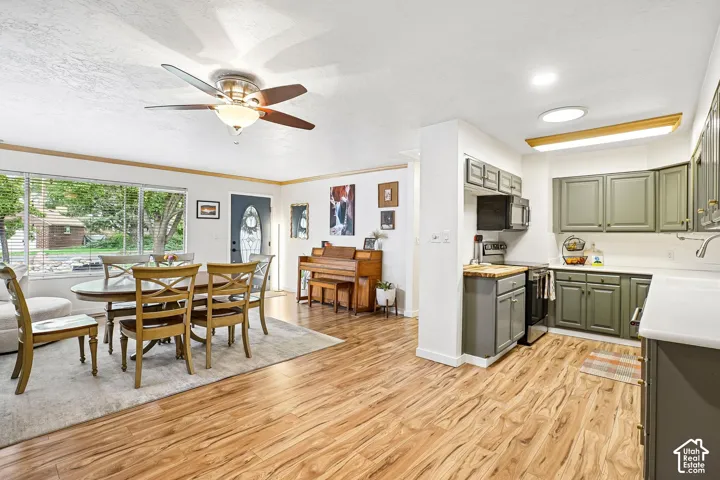 Kitchen featuring cabinetry with matte olive finish, white countertops, built-in microwave, and wood-finish flooring throughout