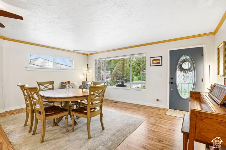 Wood-finish flooring, oversized picture window, and exterior door with a decorative oval glass insert