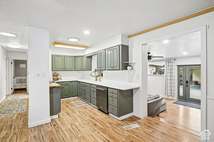 Kitchen featuring sage-toned cabinetry, light-toned countertops, wood-finish flooring, and recessed ceiling lighting