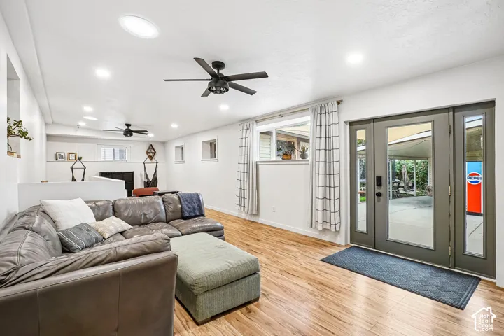 Interior space featuring wood-finish flooring, dual ceiling fans, recessed lighting, and a glass-paneled exterior door