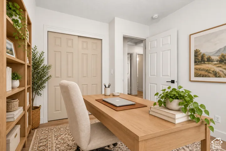 Room featuring wood-finish flooring, six-panel interior doors, and a double-door closet with recessed panels