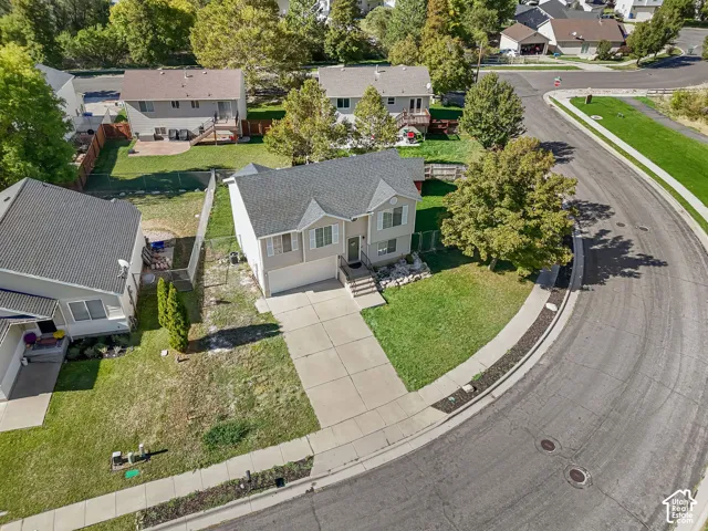 Two-story residence featuring light-toned siding, asphalt shingle roofing, an attached two-car garage, concrete driveway, and mature landscaping