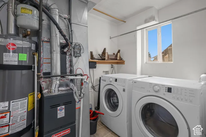 Utility area featuring a gas-fired water heater, a high-efficiency furnace, a dedicated laundry area with white appliance hookups, and a window for natural light