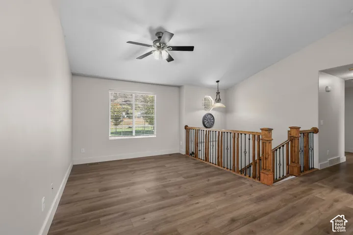 Vaulted ceilings, wood-finish flooring, and a ceiling fan with integrated lighting