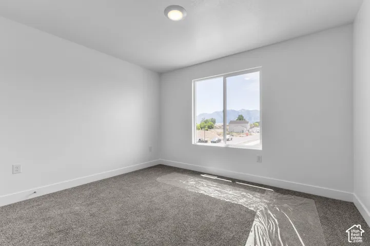 Neutral-toned wall-to-wall carpeting, single-pane sliding window, recessed ceiling lighting, and mountain scenery