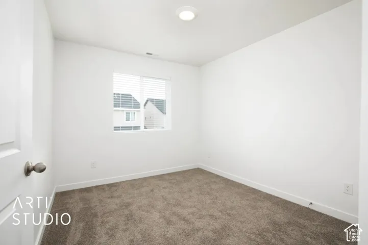 Interior space featuring neutral wall tones, wall-to-wall carpeting, a window with horizontal blinds, and a recessed ceiling light