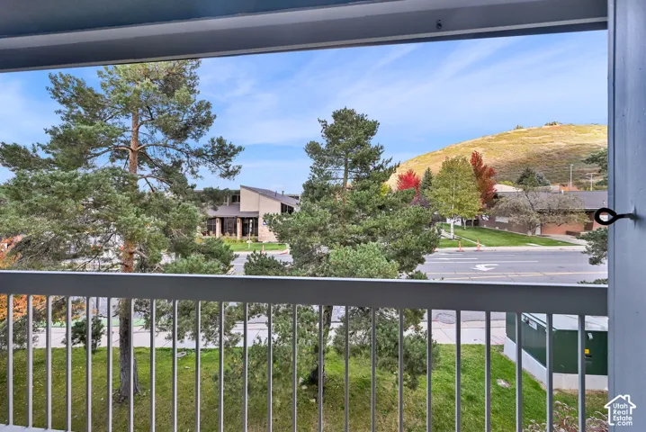 Covered balcony featuring white metal railings and mountain scenery