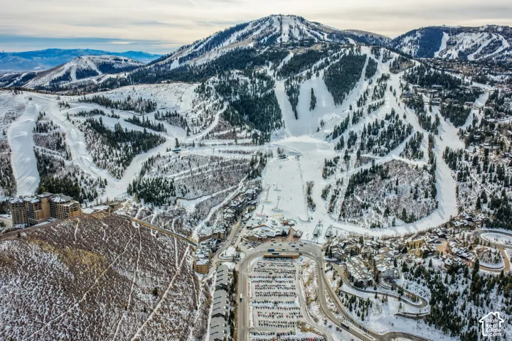 Expansive mountain backdrop featuring prominent snow-covered alpine terrain and multiple groomed ski runs