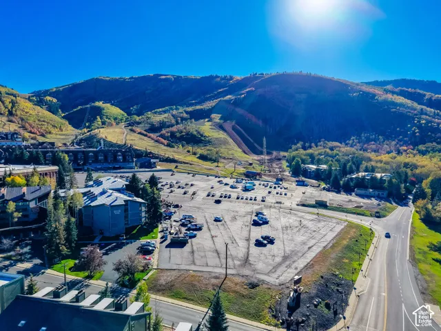 Aerial perspective featuring mountain terrain, elevated slopes, and paved surface parking