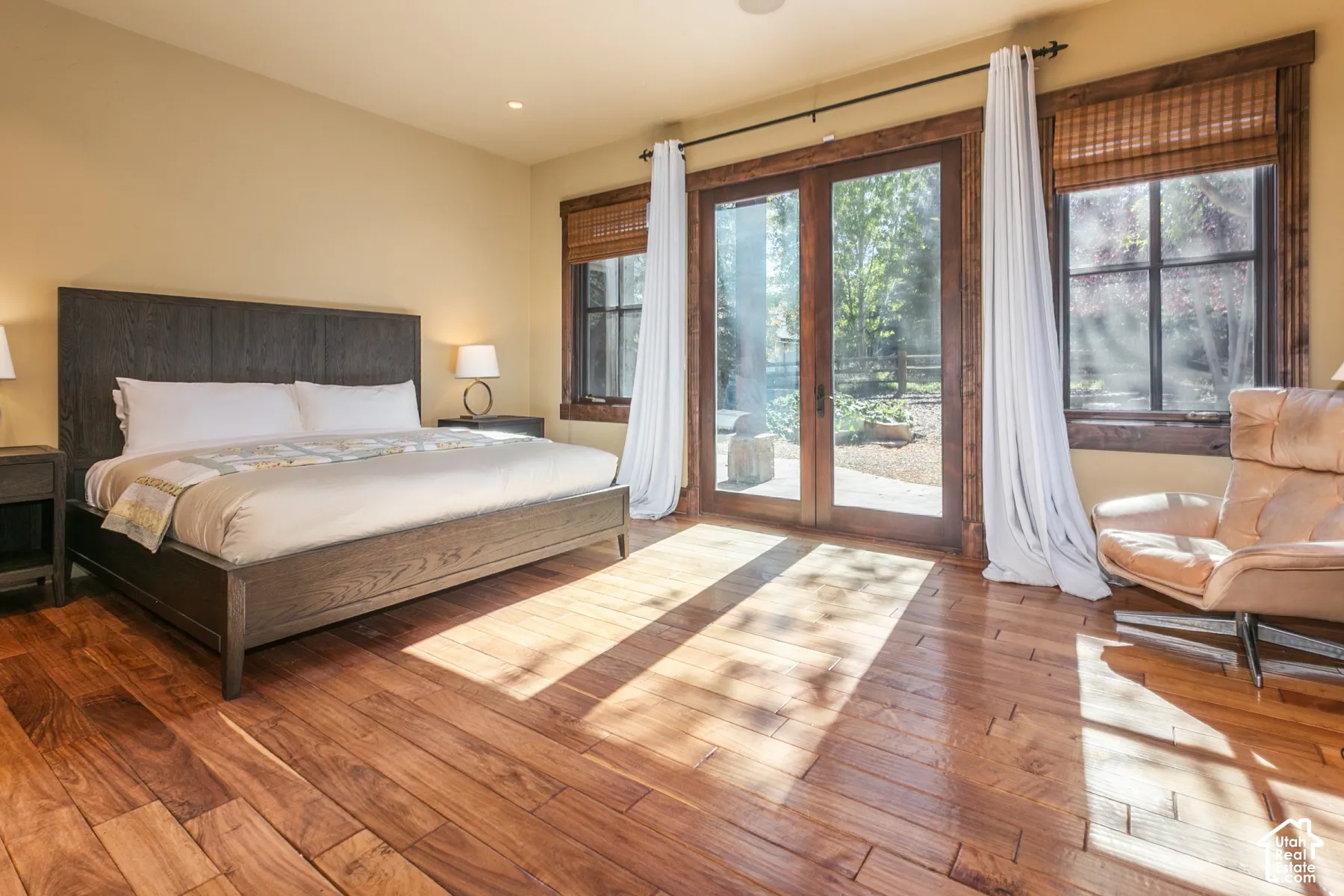 Hardwood flooring, natural wood trim, and glass paneled doors with exterior access