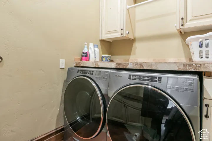 Laundry space featuring solid-surface countertops, wall-mounted cabinetry, and a mounted garment hanging rod