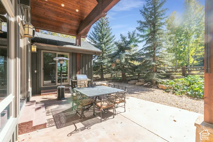 Covered patio featuring a wood-plank ceiling, recessed lighting, concrete flooring, and vertical wood siding