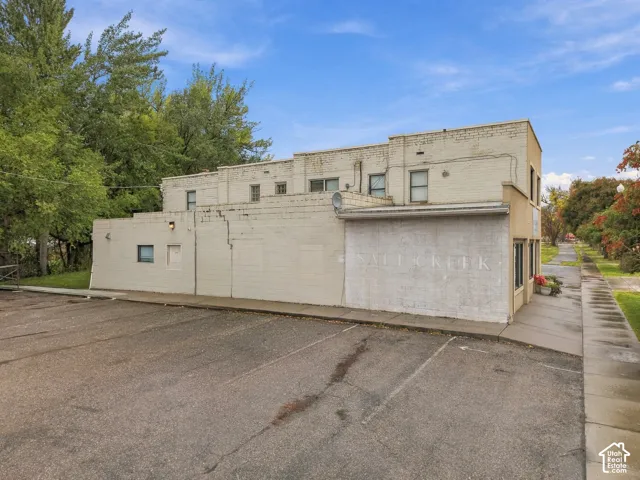 Two-story masonry structure with painted brick exterior, flat roofline, and attached asphalt parking lot