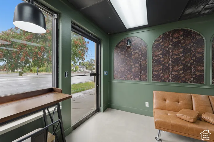 Large floor-to-ceiling windows, built-in wooden counter, arched wall insets with patterned wallpaper, pendant lighting, and solid-surface flooring