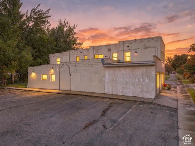 Masonry exterior building featuring dedicated asphalt parking and wall-mounted exterior lighting