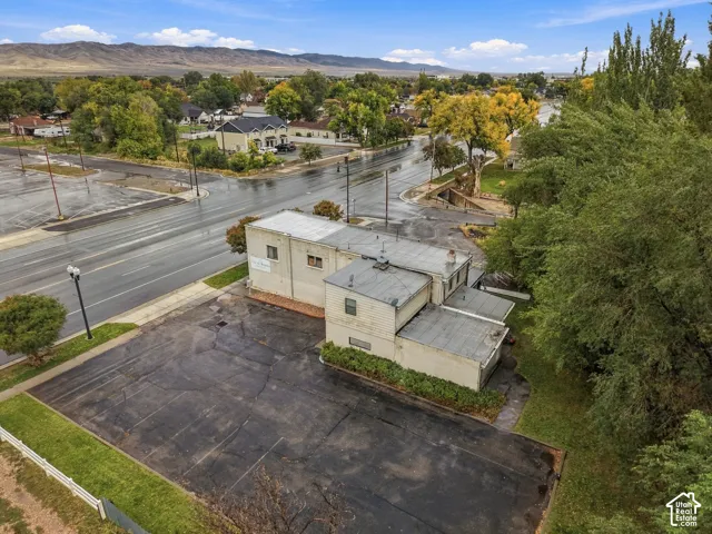 Exterior structure featuring multi-level rooflines, dedicated asphalt parking area, and mountain range backdrop