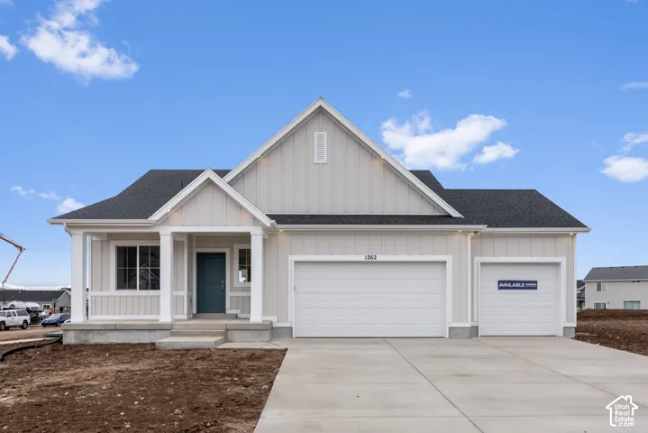 Board and batten siding, asphalt shingle roof, covered front porch with square columns, and three-car garage