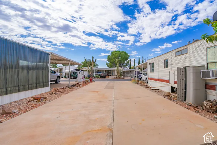 Concrete driveway with dual covered parking structures and xeriscape landscaping