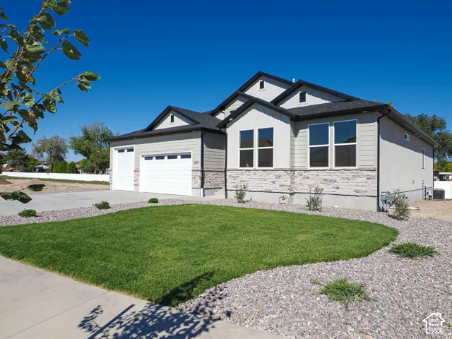 Single-story residence featuring a multi-gabled roofline, horizontal siding, stone veneer accents, and an attached two-car garage
