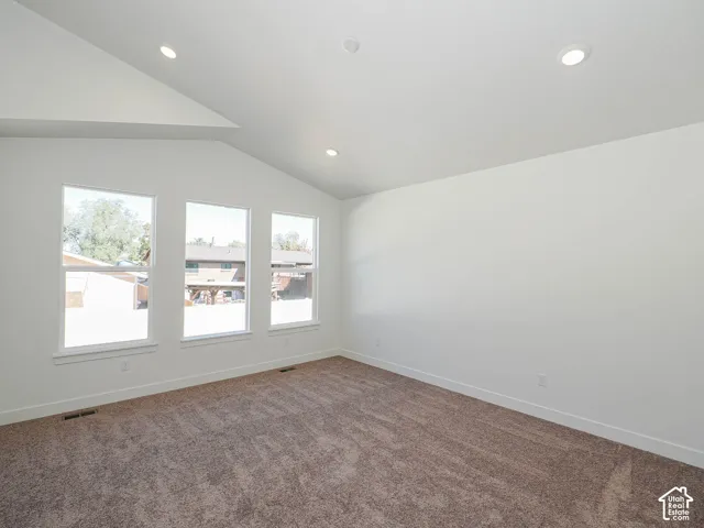 Vaulted ceiling featuring recessed lighting, neutral carpeting, and three expansive windows