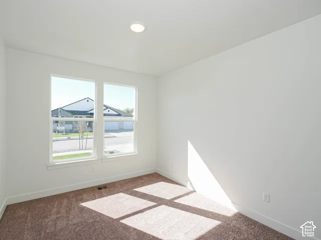 Neutral-toned carpeting, dual-pane windows with white trim, and recessed LED ceiling lighting