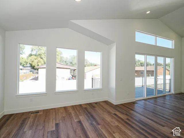 Vaulted ceilings featuring recessed lighting, expansive windows, glass sliding doors, and wood-finish flooring