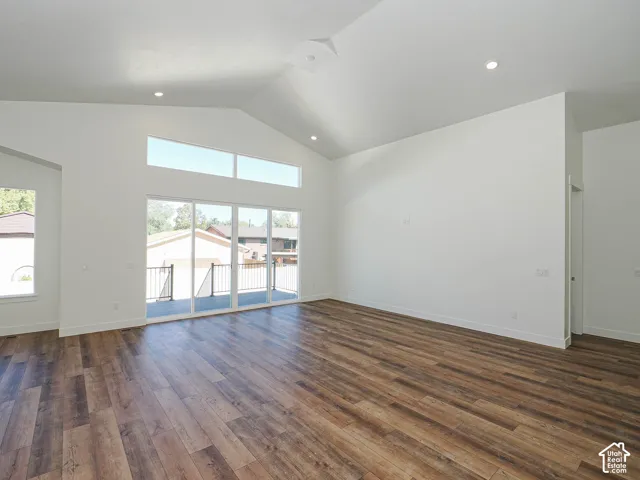 Vaulted ceilings with recessed lighting, wood-finish flooring, transom windows, and sliding glass doors with exterior access