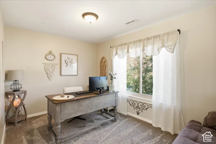 Room featuring neutral-toned carpeting, flush-mount ceiling lighting, and a large window with natural exterior light
