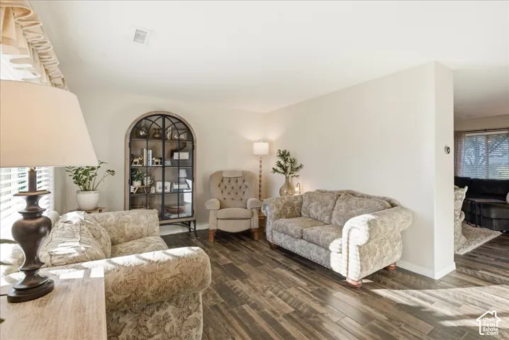 Living space featuring wood-finish flooring and a built-in arched display cabinet with glass shelving