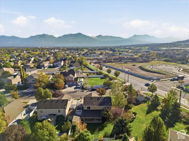 Aerial perspective featuring residential lots, mature landscaping, and an expansive mountain range backdrop