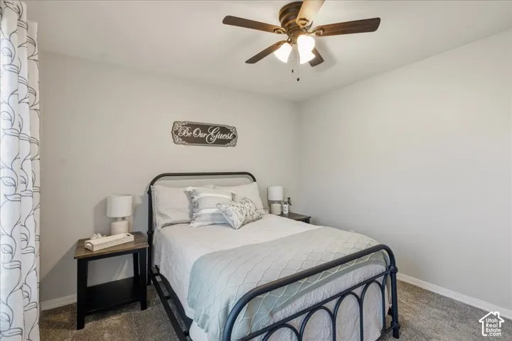 Neutral-toned interior room featuring wall-to-wall carpeting and a ceiling-mounted fan with integrated light fixtures