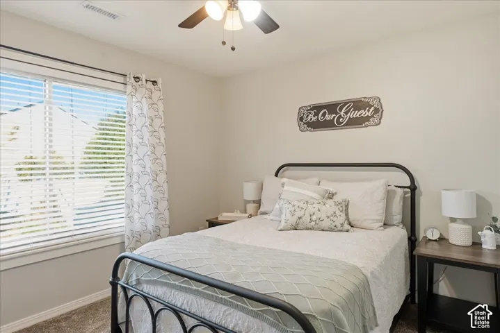 Neutral-toned walls, carpeting, and a ceiling-mounted light fixture with a fan