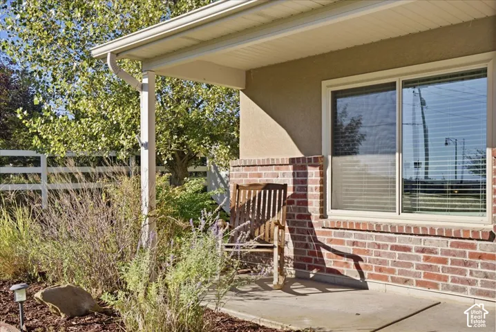 Covered front porch featuring a concrete foundation, brick masonry accents, and a sliding window