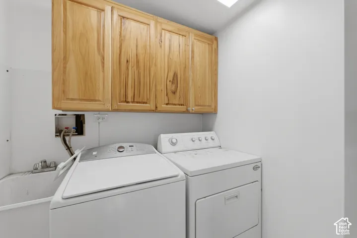 Utility room featuring upper natural-finish wood cabinetry and a built-in utility sink