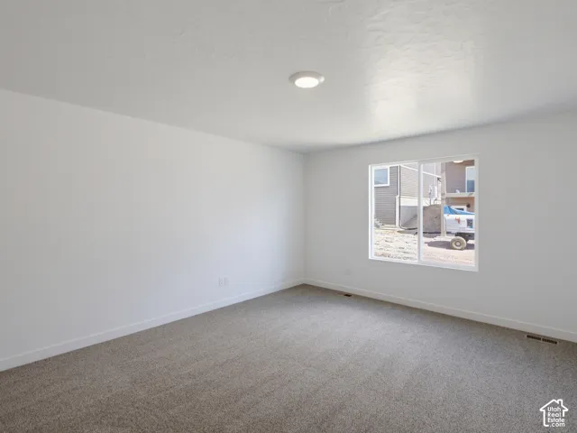 Neutral interior featuring wall-to-wall carpeting, crisp white wall finishes, and a single recessed ceiling light