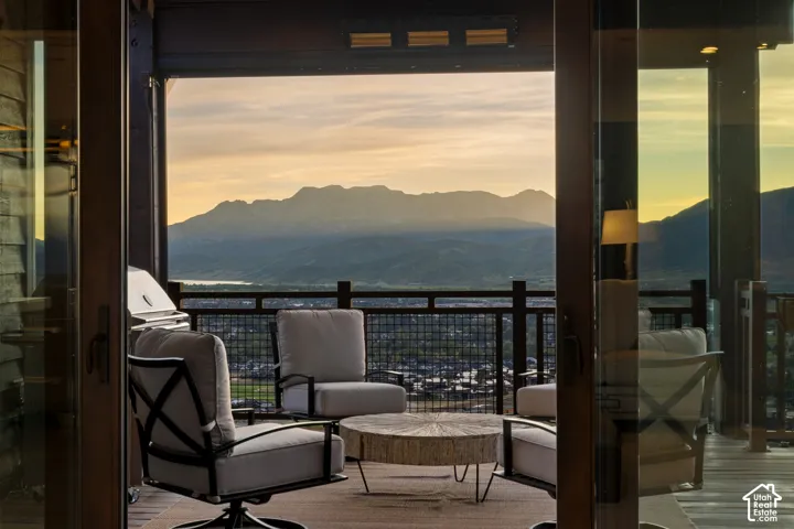 Covered deck featuring wood-finish decking, dark metal railings, and mountain backdrop scenery