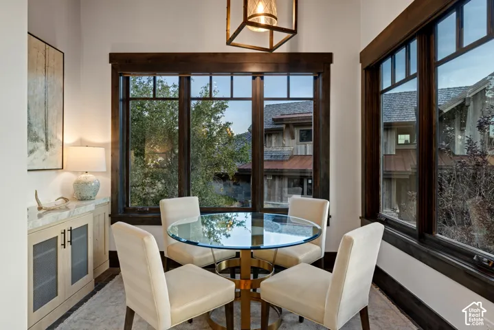 Built-in cabinetry with stone-surface countertop, floor-to-ceiling windows with dark wood trim, and geometric pendant lighting