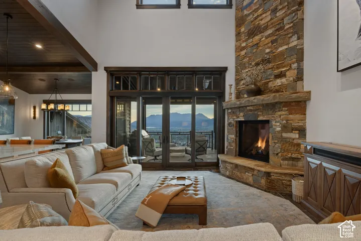 Floor-to-ceiling stone fireplace, vaulted ceilings, multi-panel sliding glass doors, dark wood-finish trim, and recessed lighting
