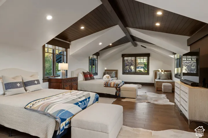 Vaulted ceilings with dark wood-finish planking, exposed structural beams, recessed lighting, wood-finish flooring, and multi-pane windows with dark trim