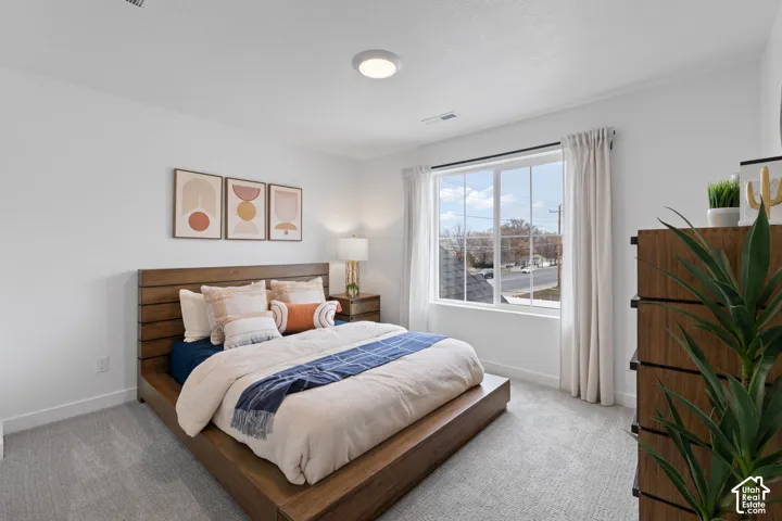 Neutral wall-to-wall carpeting, single-pane window with white muntins, and a flush-mount circular ceiling light