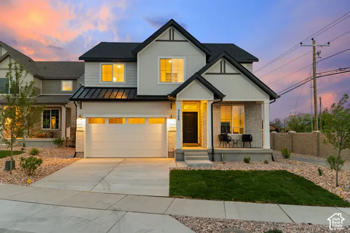 Two-story exterior featuring a mixture of siding and masonry, a metal roof accent, and an attached two-car garage